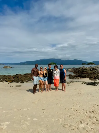 Un grupo de viajeros con Moisés en la playa
