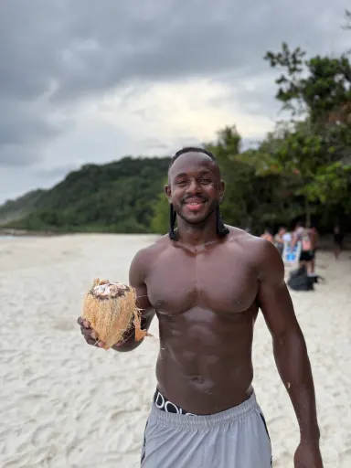 Moisés con un coco en la playa